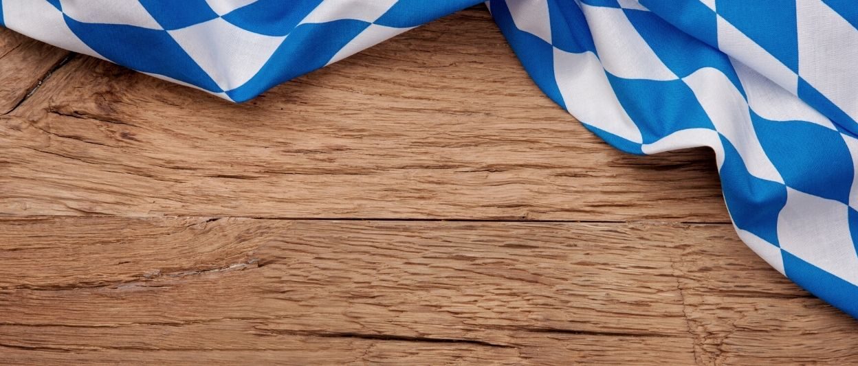 Wood table with blue and white bavarian flag draped over top right corner