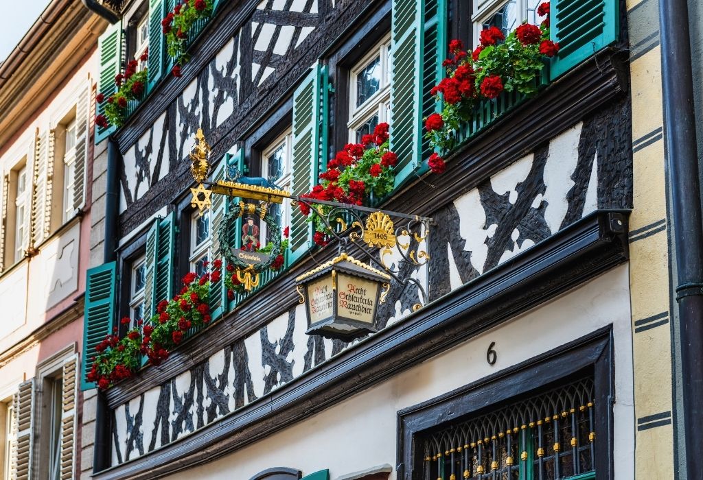 Half timbered house with black wood and white walls and green window shutters - Brewery Schlenkerle Bamberg